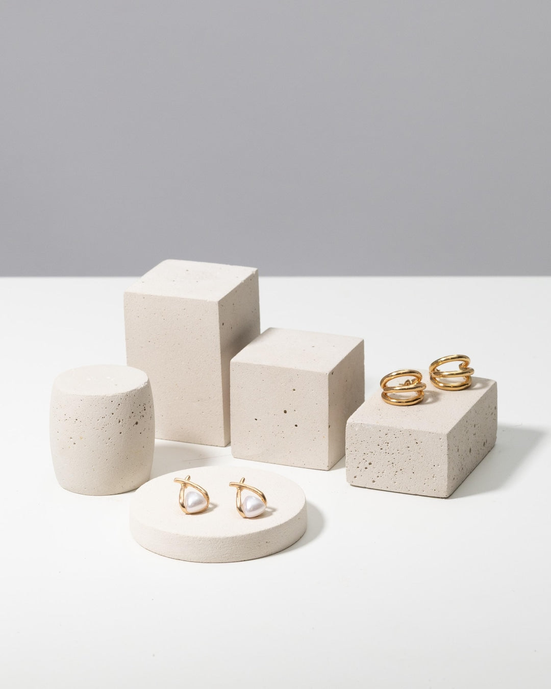 Betonvton off-white jewelry photography props styled with gold hoop and pearl earrings