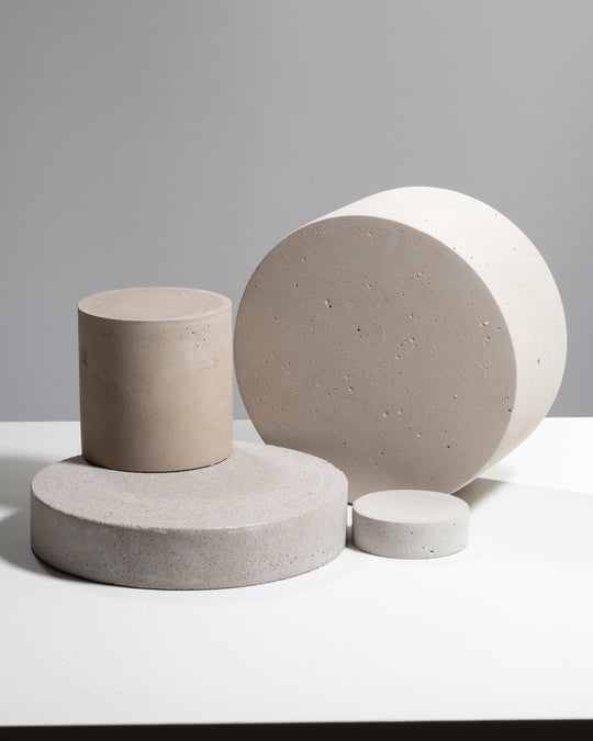 Set of four neutral concrete cylinder photography props in different sizes for product styling