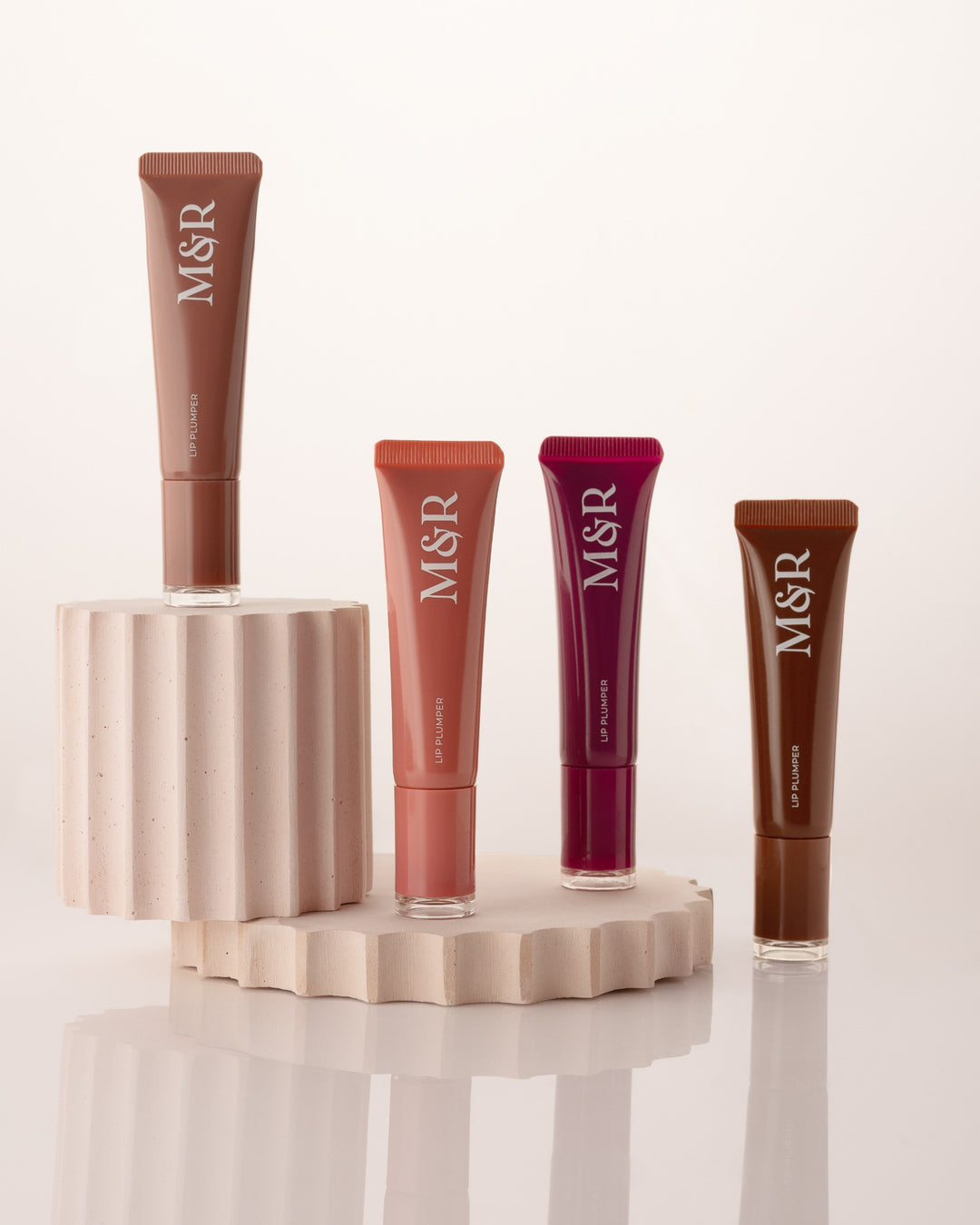 Cosmetic lip products styled on fluted mineral photography props by Betonvton