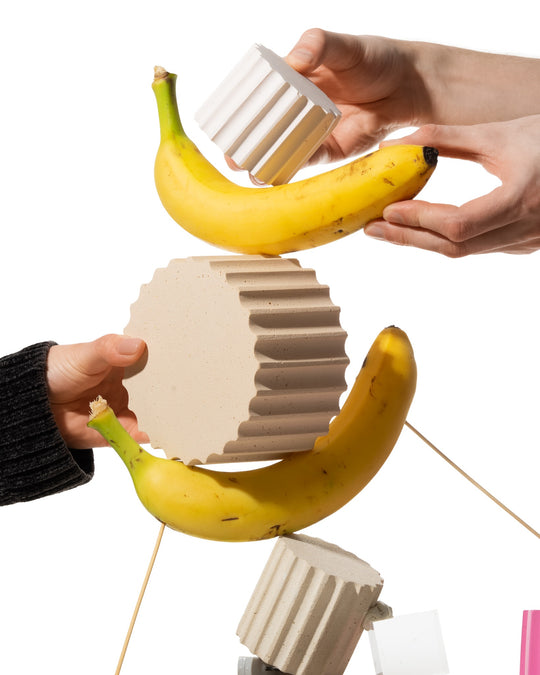 Hands rearranging modular fluted Betonvton props during a creative product photography shoot