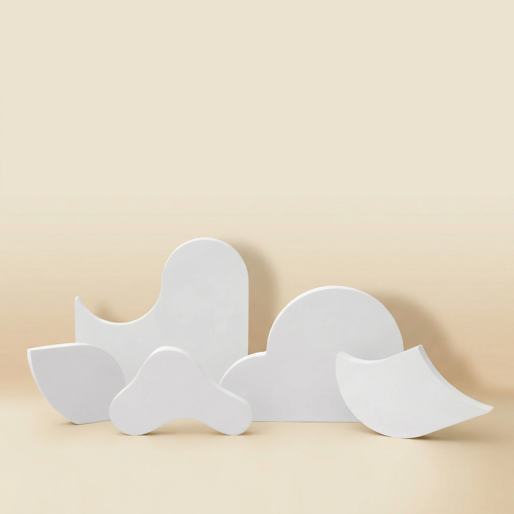 Set of four white sculptural jewelry display stands with organic wave shapes, handmade gypsum risers for necklaces and cosmetics product photography