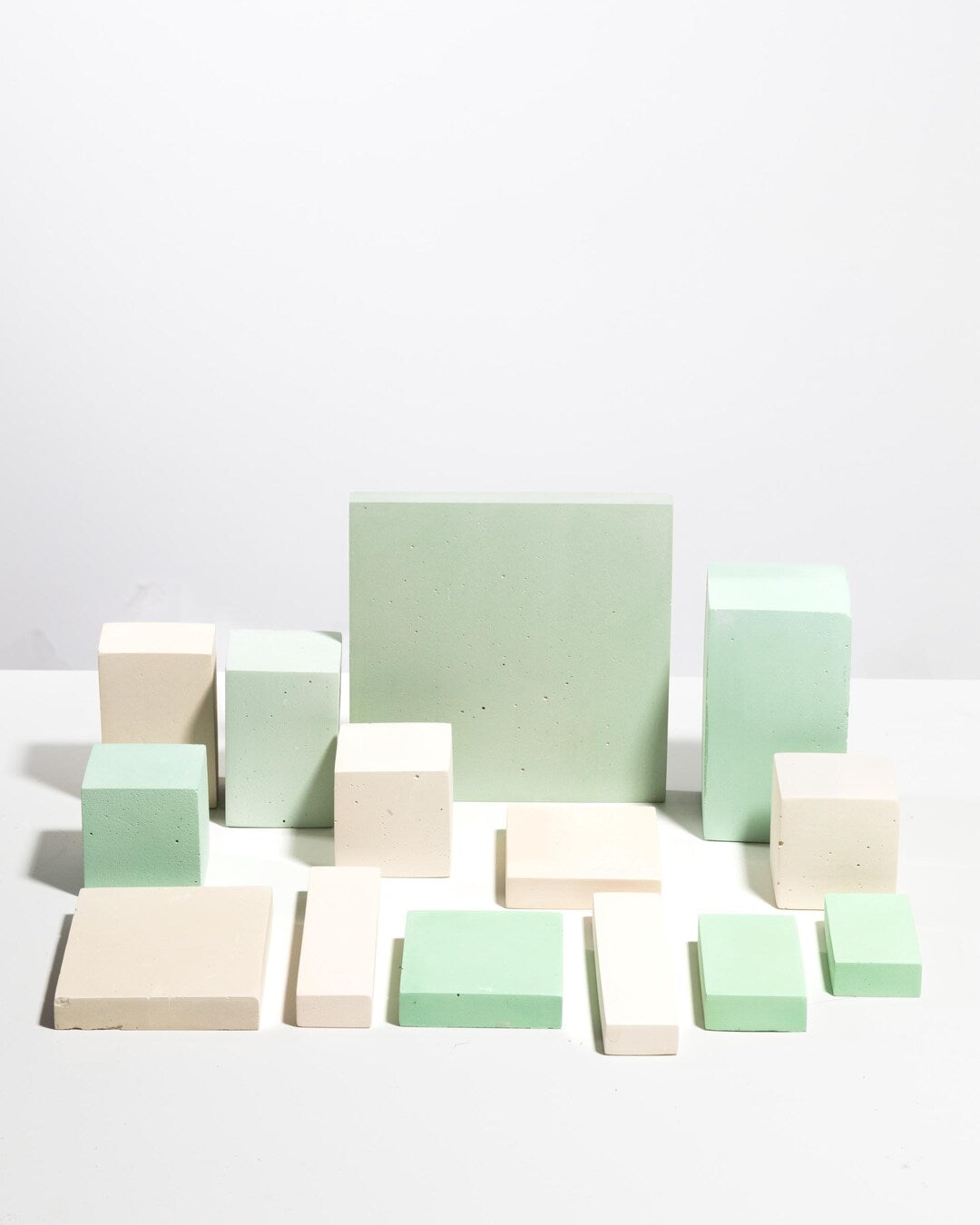 Set of geometric display blocks in pale mint green and soft cream tones