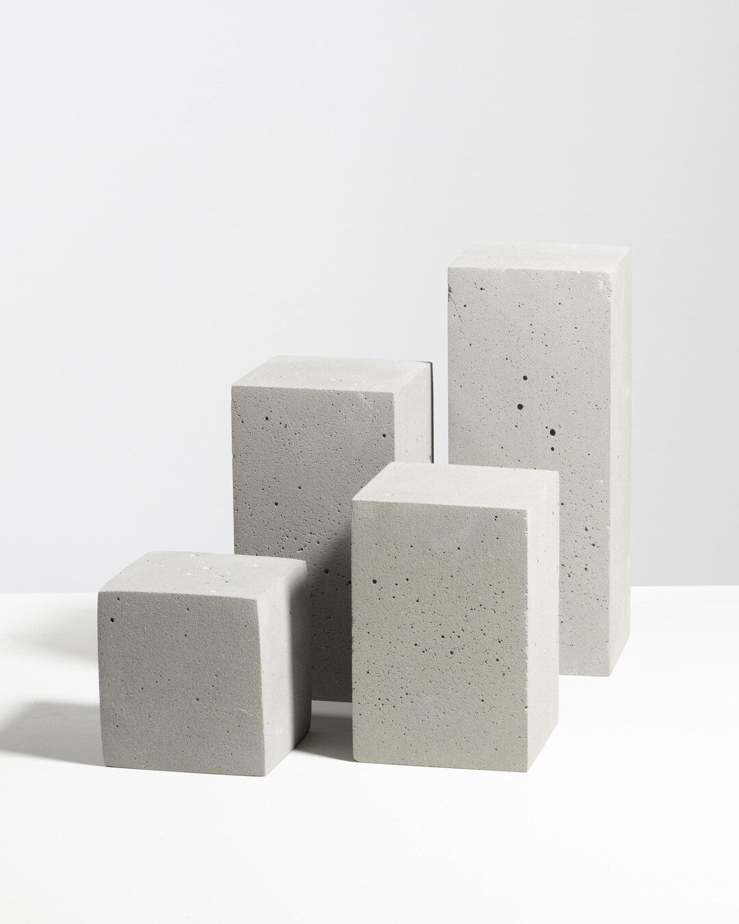 Grey concrete retail display pedestal set styled for product presentation