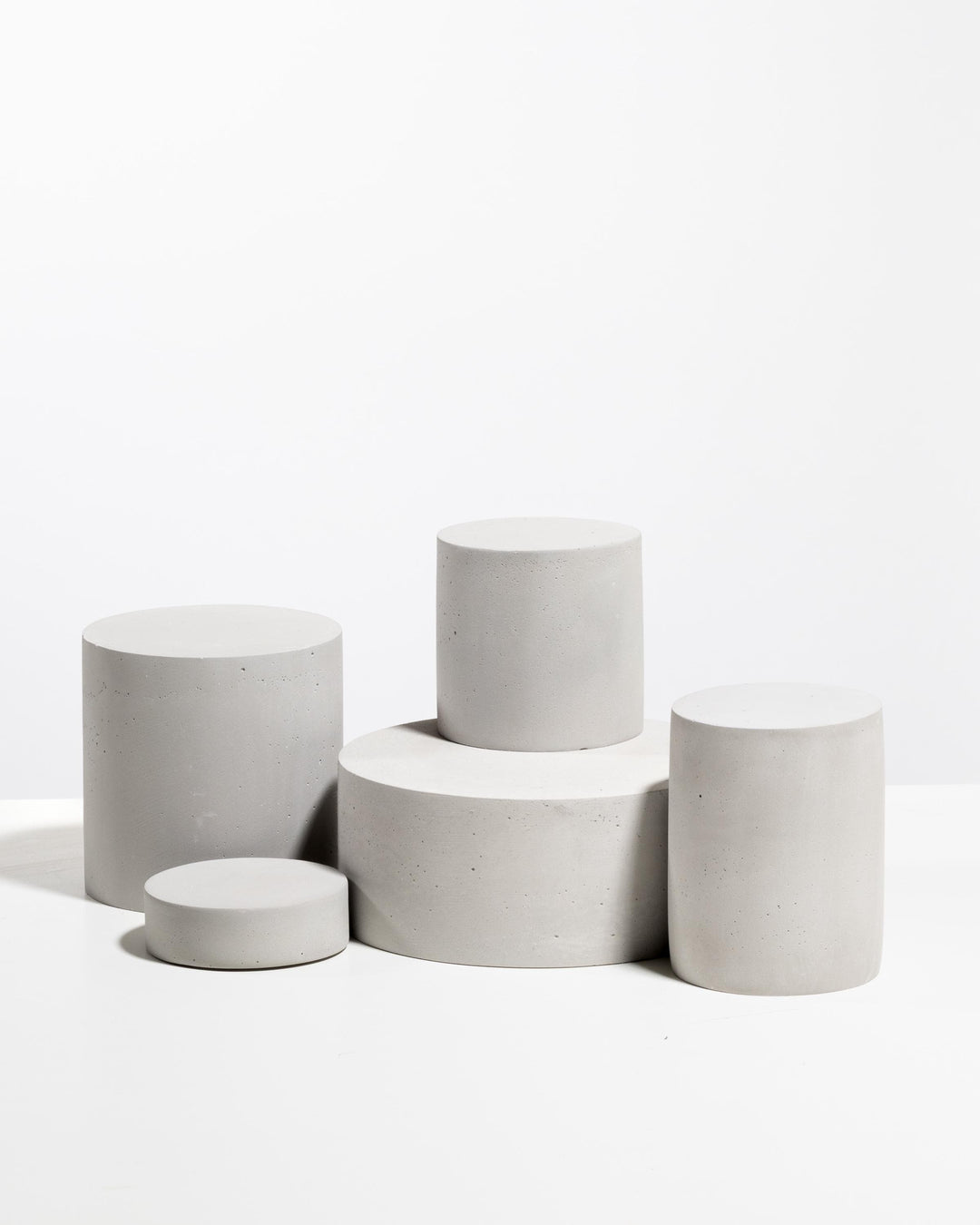 Minimal architectural display riser set in white concrete for cosmetic brands