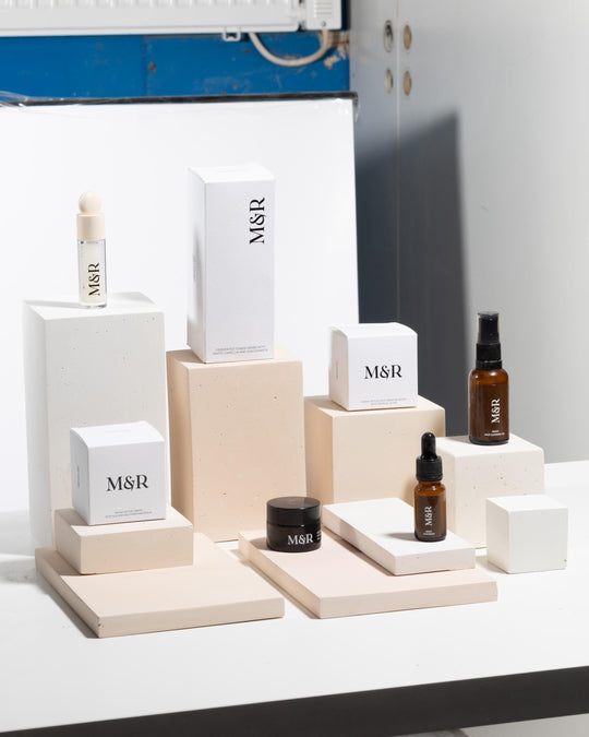 Skincare products displayed on white concrete blocks of varying heights