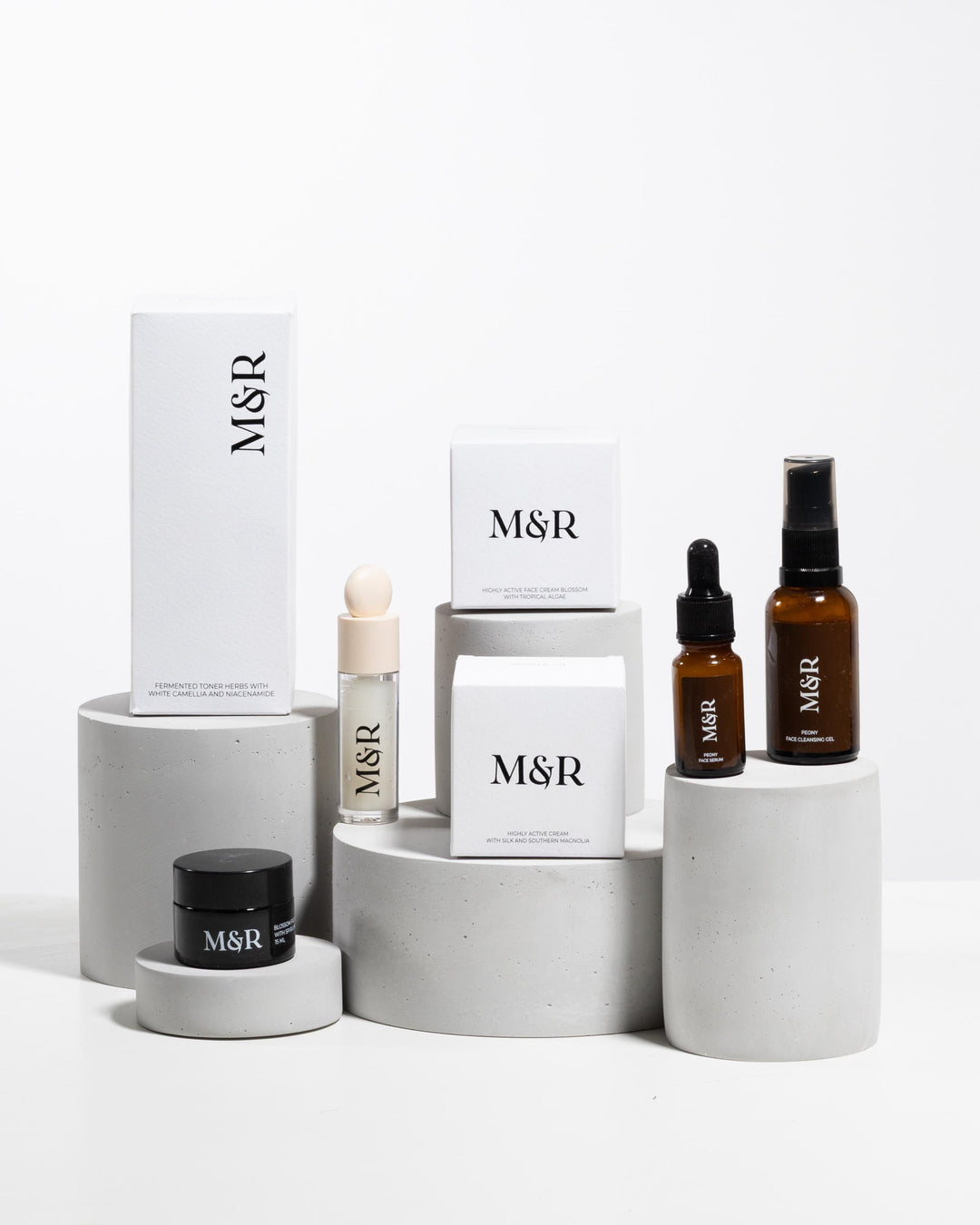 Concrete cylinder display risers styled with luxury skincare packaging on boutique counter
