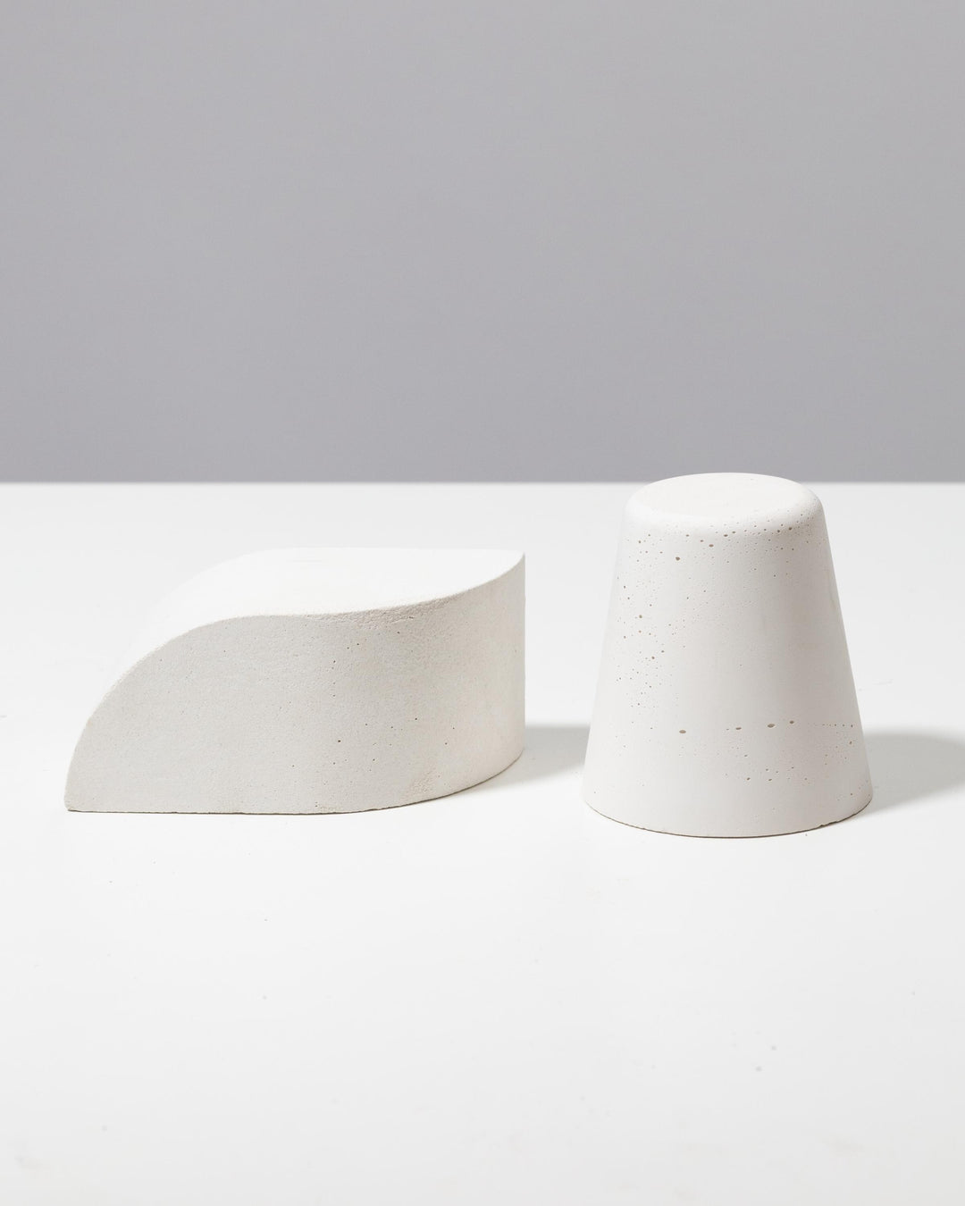 Off white plaster wedge riser and truncated cone pedestal duo for retail display