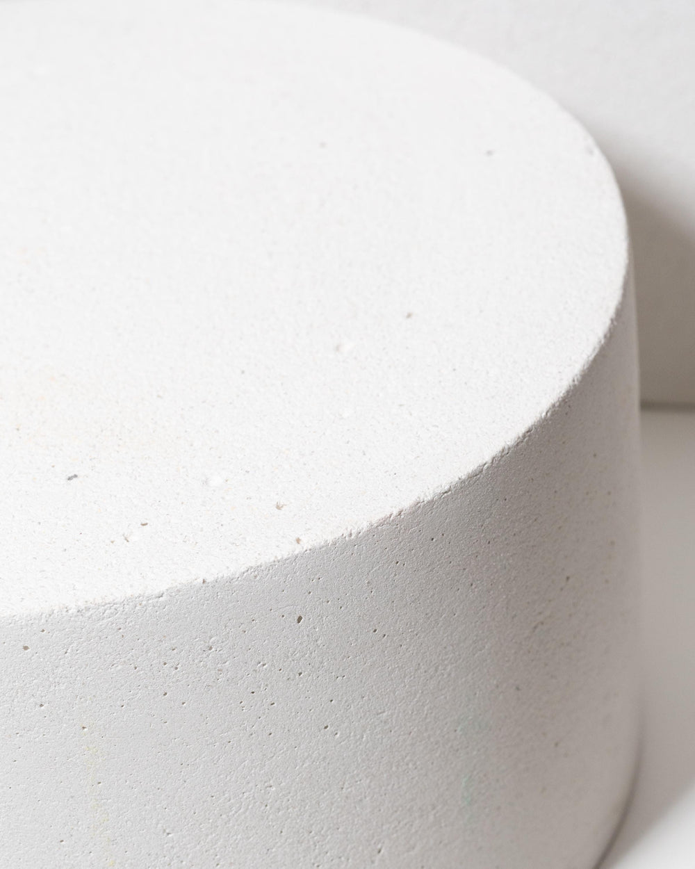 Round plaster display platforms in light grey for product styling