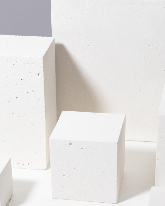 White geometric blocks with porous texture including tall prism and flat panel
