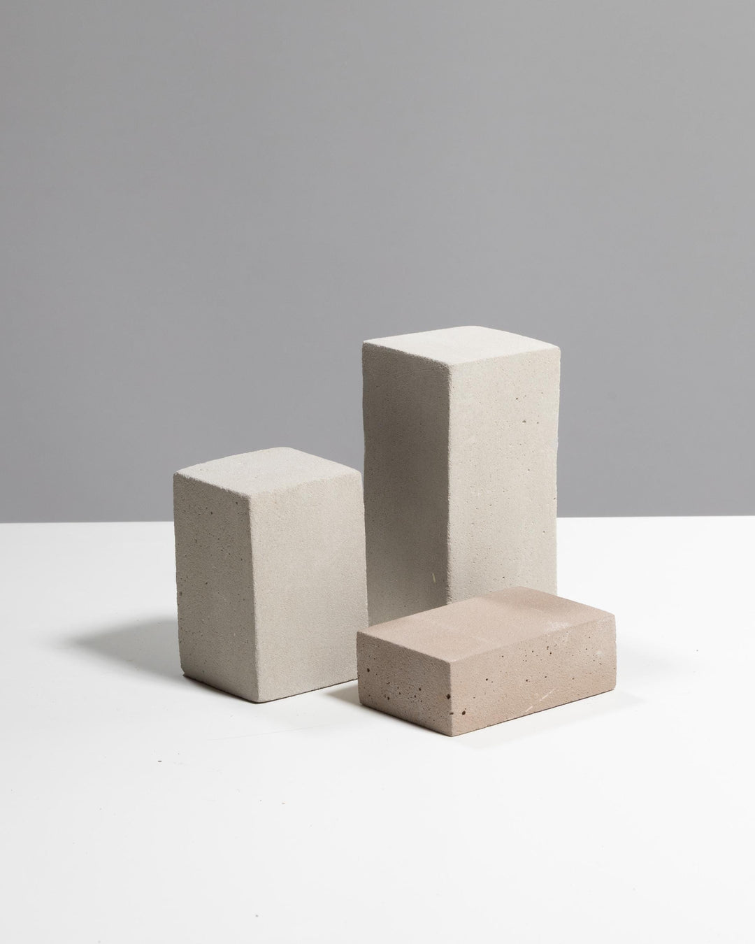 Grey beige plaster display riser trio with three rectangular blocks at different heights