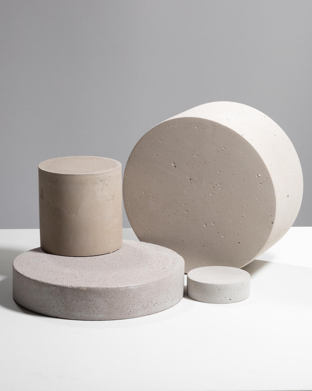 Light grey plaster disc and column display set of four pieces
