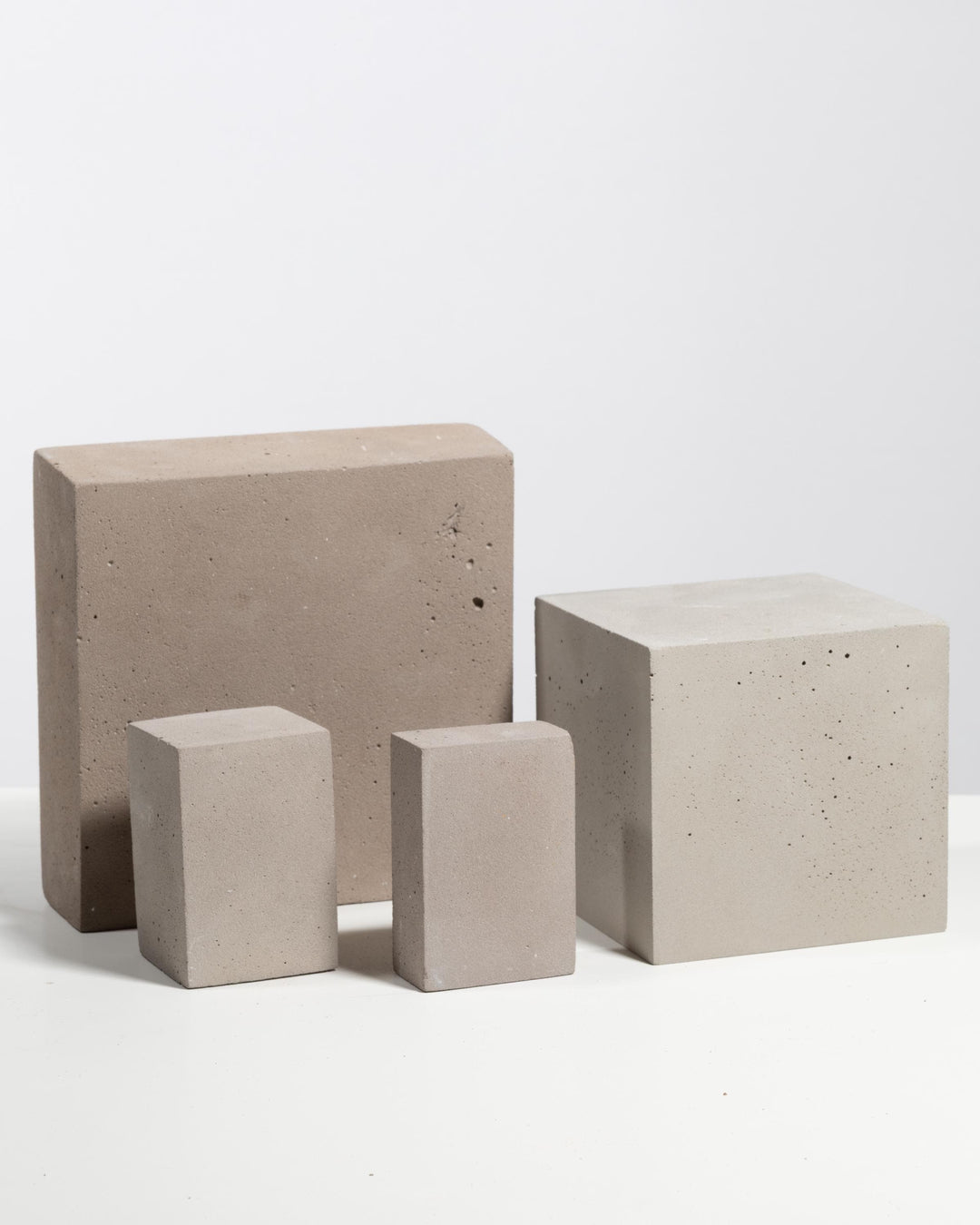 Grey and beige plaster block riser set of four for product display