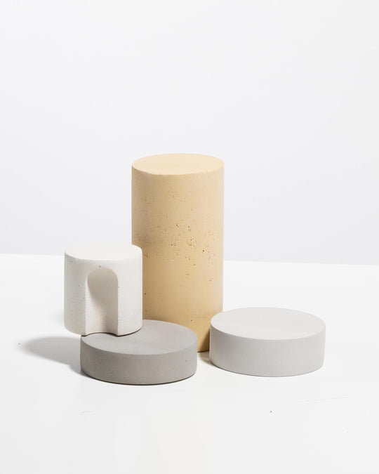 Plaster display set with beige cylinder white arch block and two grey discs