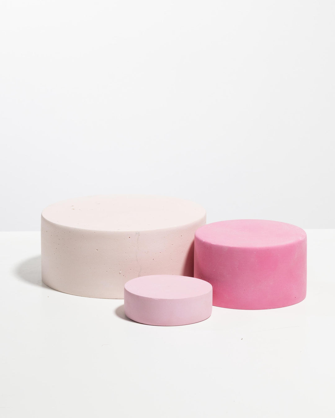 Round concrete soap display trays in three pink tones with matte finish