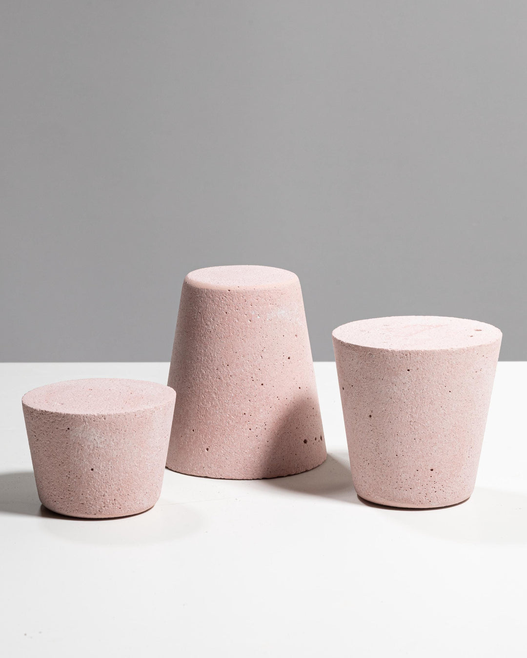 Dusty pink plaster display set with three tapered podiums of different heights