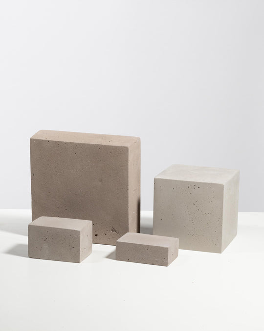 Four textured plaster blocks in grey and beige with porous surface