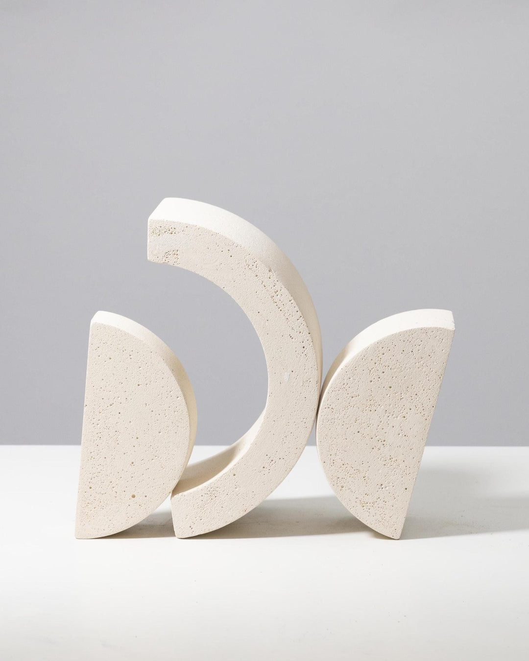 Off white plaster riser set with nested arch and half circle shapes, porous mineral texture