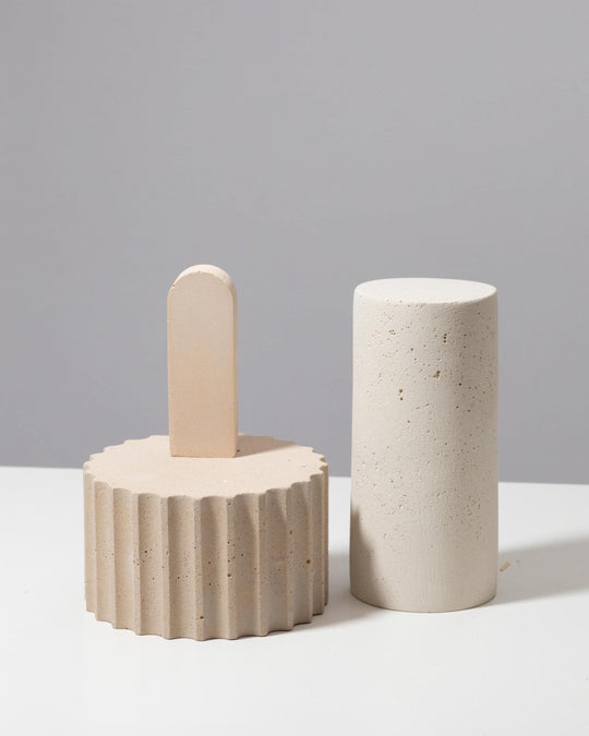 Beige plaster display set with fluted pedestal, arch piece and tall cylinder pillar